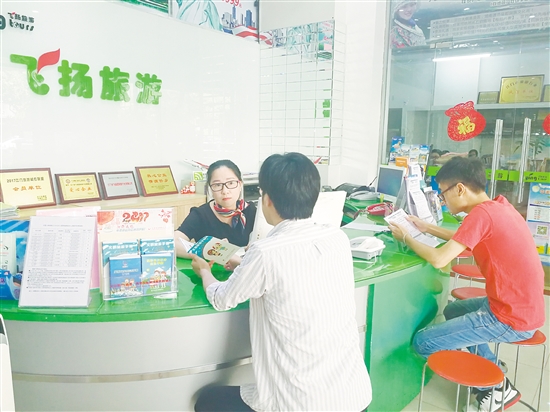 前台销售在跟客人介绍文明旅游注意事项。