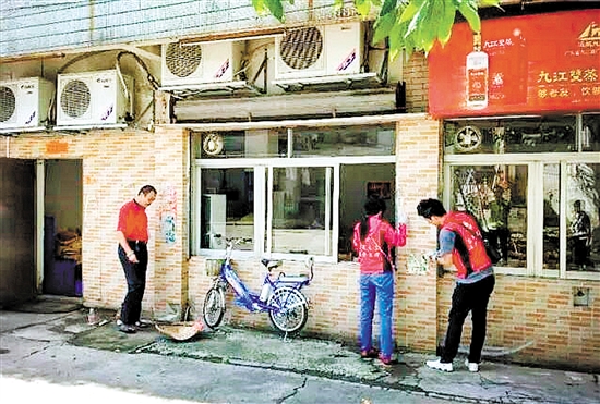 义工、社工、热心市民清理“牛皮癣”。
