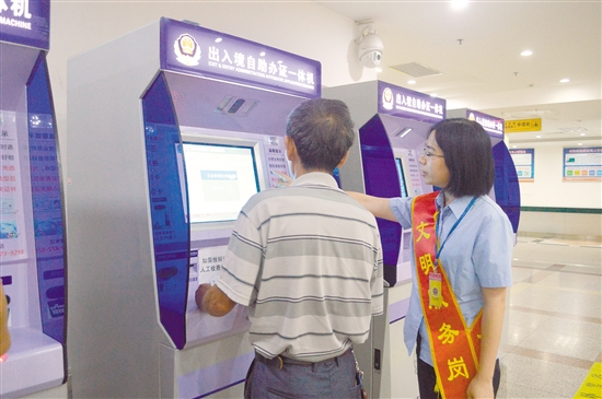 工作人员指引办事群众使用自助办证一体机。李千帆